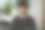 在一个现代公寓的客厅里，一个英俊的男人看着镜头，微笑着，背景是家里的鲜花图片下载