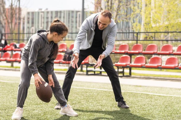 一家人在公园一起踢美式足球。图片下载