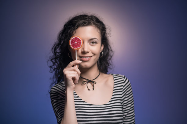 工作室拍摄的黑发女人拿着美味的糖果图片下载