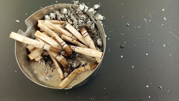 不锈钢烟灰缸里一堆用过的烟头近照图片下载