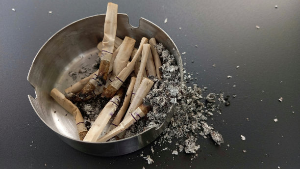 不锈钢烟灰缸里一堆用过的烟头近照图片下载