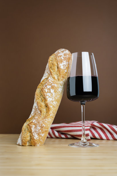 简约的构图搭配一杯红酒和一根法棍面包。图片下载