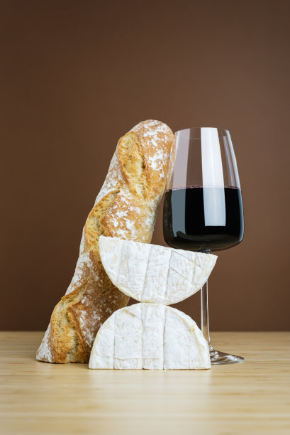 一杯红酒，一个法棍面包和卡门贝尔奶酪的简约组合。图片下载