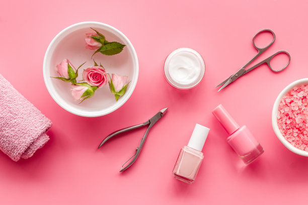 专业美甲工具与粉红色的玫瑰花。美容护理沙龙水疗。图片下载