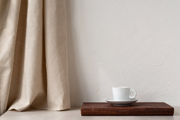 棕色木桌上的白色咖啡杯，中性米色亚麻窗帘和石桌，空白的白色墙面背景，极简优雅的家居室内设计模板与复制空间图片下载