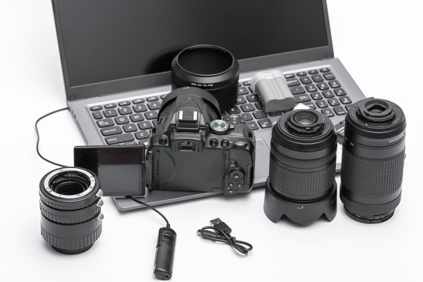 白色背景的笔记本电脑上摆放着照相设备图片下载