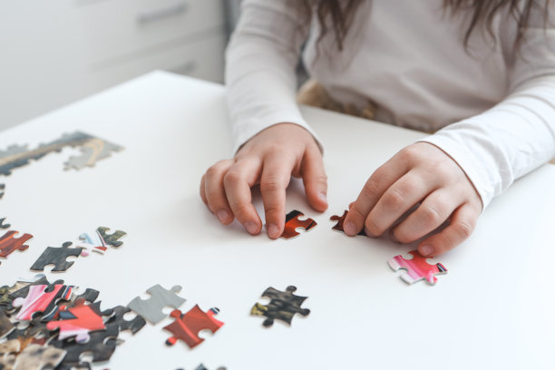 孩子在桌上做拼图的手图片下载
