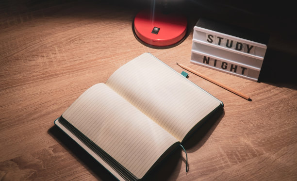 学习概念背景。记事本与空白页和台灯在木桌高角度看。学习时间概念图片下载
