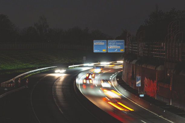 夜间行驶在道路上的汽车，被过往的灯光条纹所突出。法兰克福,德国。图片下载