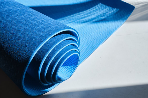 特写瑜伽垫在一个光明的背景。健康与运动理念图片下载