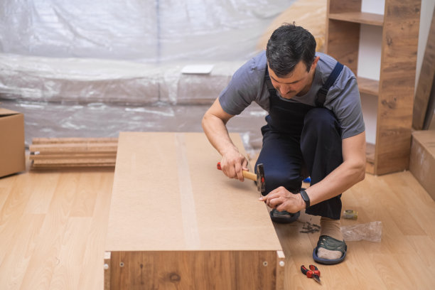 家具生产企业的工人正在把钉子钉进木柜里图片下载