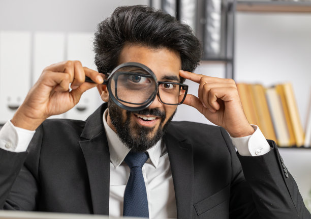 商人拿着放大镜靠近脸，用放大的大眼睛看，搜索，分析图片下载