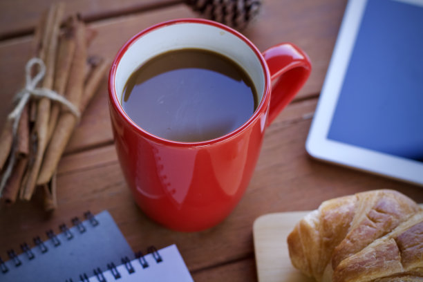 在一个美好的早晨，坐在办公桌上喝一杯热咖啡。图片下载