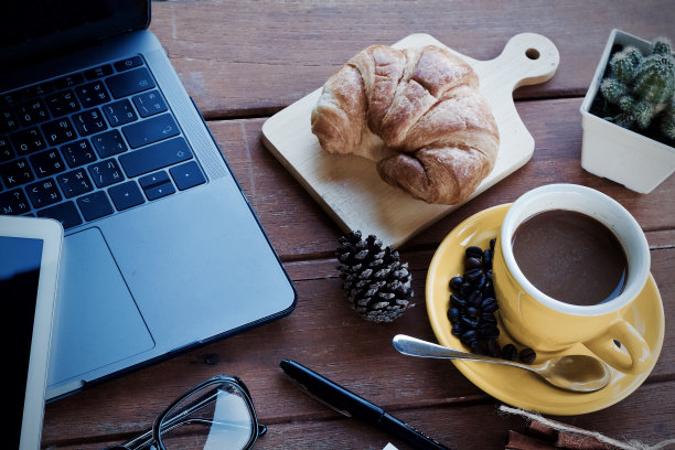 在一个美好的早晨，坐在办公桌上喝一杯热咖啡。图片下载