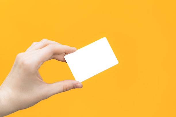 手里拿着空白的白卡片，背景是黄色的图片下载