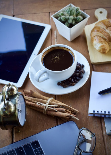 在一个美好的早晨，坐在办公桌上喝一杯热咖啡。图片下载