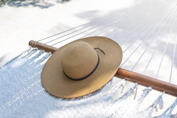 一顶草帽躺在马尔代夫的吊床上。旅游和热带度假的概念图片下载