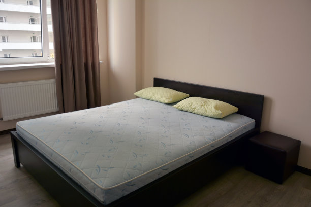 旅馆靠窗的大床上的一张双人床垫和两个枕头图片下载