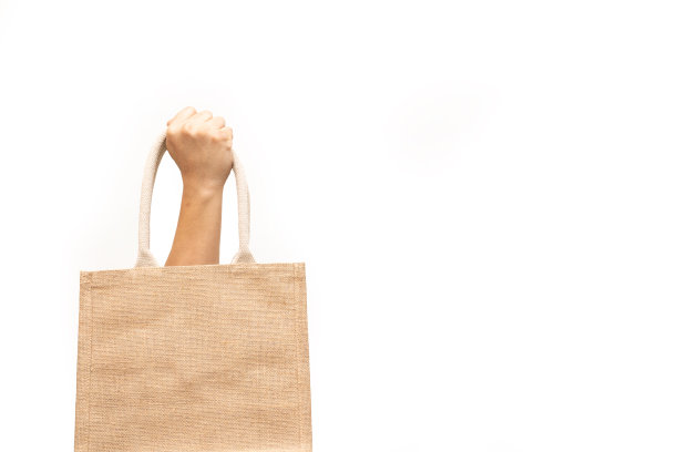 男子手持黄麻袋或麻袋在白底。可重复使用的购物袋。图片下载