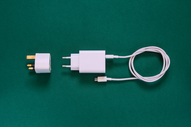 手机充电器(USB C型)和英国适配器，深绿色背景，俯视图。图片下载