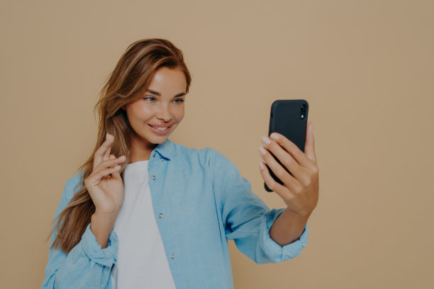漂亮的年轻女子用智能手机自拍图片下载