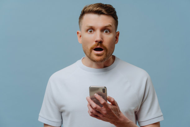 惊讶的男子在手机上阅读意想不到的新闻图片下载