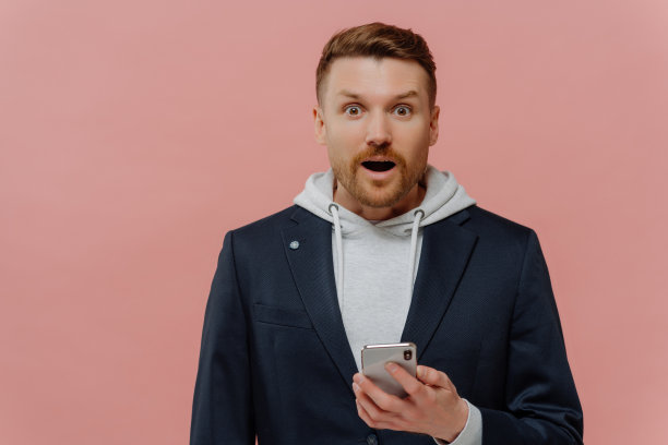 印象深刻的男子阅读最新的新闻，脸上的表情惊讶图片下载