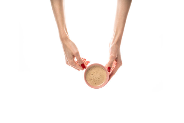 女性的手拿着白色背景的白色陶瓷杯。咖啡杯，咖啡杯，拿铁，卡布奇诺，三合一咖啡。女性的手，鲜红的指甲。孤立在白色背景上。图片下载