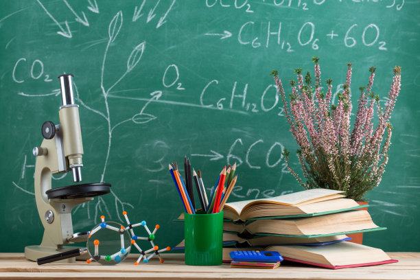教育和科学的概念——礼堂的桌子上有书本、分子模型和显微镜，背景是黑板。图片下载