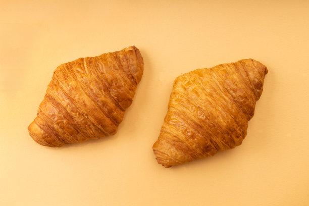 米色背景的法式新鲜羊角面包图片下载