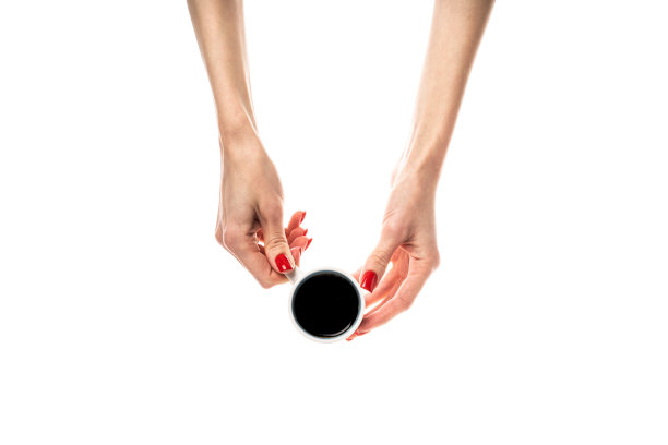女性的手拿着白色背景的白色陶瓷杯。咖啡杯，咖啡杯，拿铁，卡布奇诺，三合一咖啡。女性的手，鲜红的指甲。孤立在白色背景上。图片下载