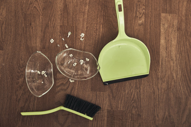 这是一个透明的杯子，上面有汤和刷子，还有一个簸箕用来清洁。公寓里的家庭清洁概念。高质量照片图片下载