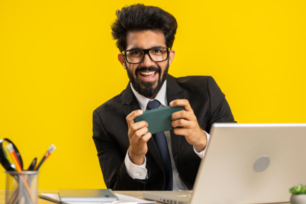 印度商人在智能手机上玩令人兴奋的手机应用程序庆祝赢得射击游戏图片下载