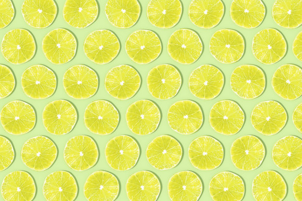 绿柠檬片与阳光在绿色背景图片下载