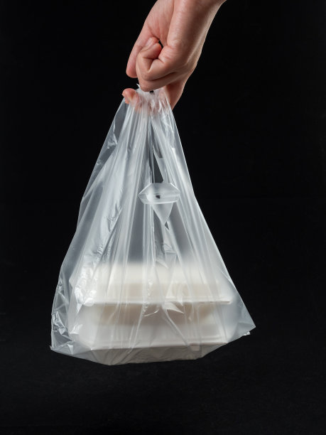 拿便当盒装在白色背景的塑料袋里图片下载