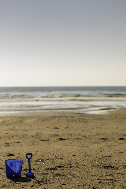 海滩上的蓝色水桶和铁锹图片下载