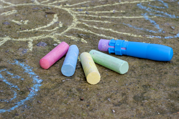 沥青上的儿童多色粉笔和粉笔架。图片下载