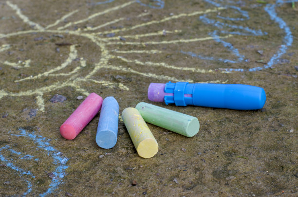 沥青上的儿童多色粉笔和粉笔架。图片下载