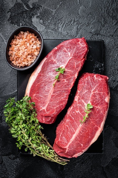 生和牛蚝油上叶牛排，有机牛肉。黑色背景。俯视图图片下载