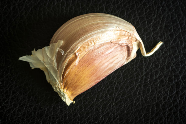 黑暗背景下的大蒜特写图片下载