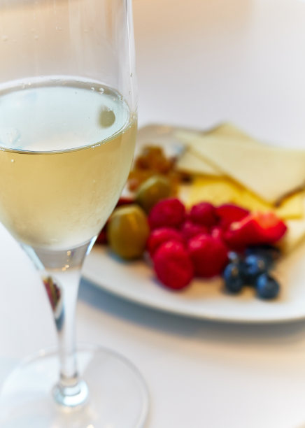 一瓶汽酒，盘子里放着水果图片下载