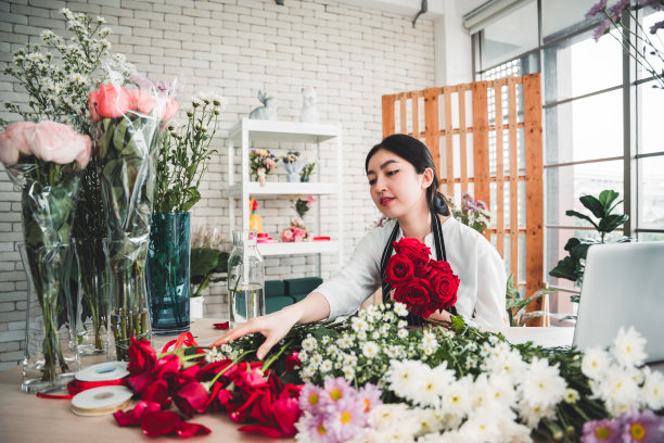 花店里，年轻的花商正在一丝不苟地修剪鲜花，准备制作一个漂亮的花瓶。图片下载