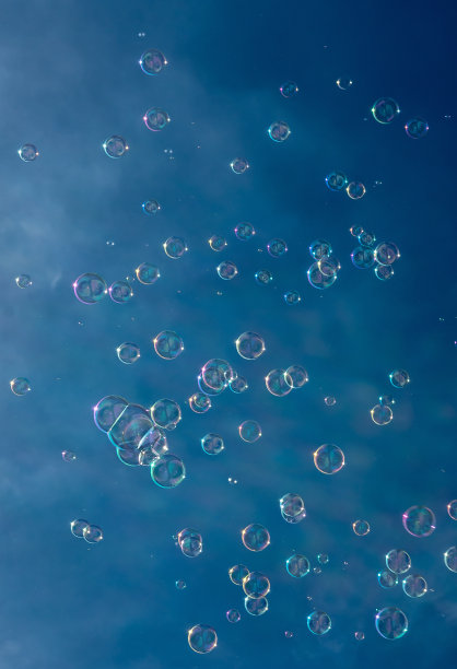 无数的彩色肥皂泡漂浮在蓝天前的半空中图片下载