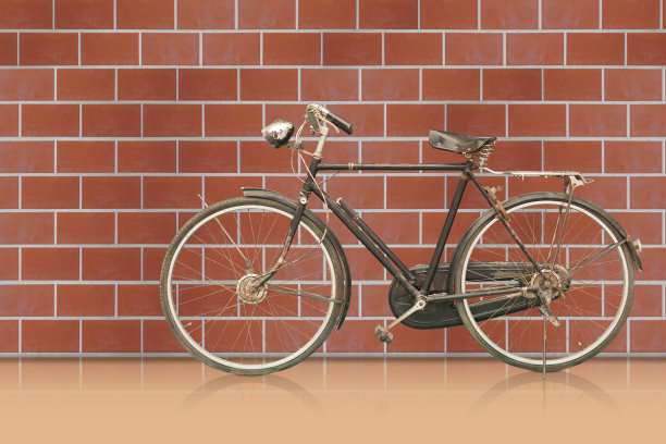 侧视图古董和铁锈黑色框架自行车在橙色地板，棕色砖墙背景，对象，装饰，运输，复制空间图片下载