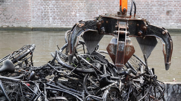 在阿姆斯特丹的一条运河里，一个机械抓取器被用来清理旧自行车。图片下载