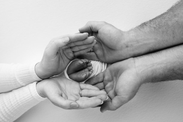 孩子的腿在母亲、父亲、父母的手中。一个小新生儿的脚特写。小宝宝的脚。妈妈和她的孩子。幸福家庭概念。母亲的黑白照片。图片下载