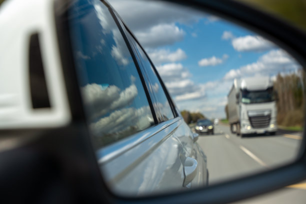 半挂车和其他车辆在多车道高速公路上行驶时的侧视镜中散焦图片下载