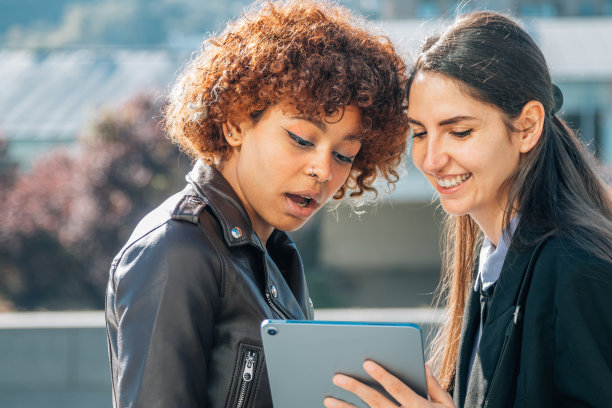 女孩向惊奇的朋友展示装置图片下载