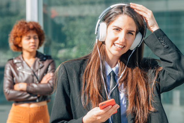 在城市里拿着手机和耳机的女商人图片下载