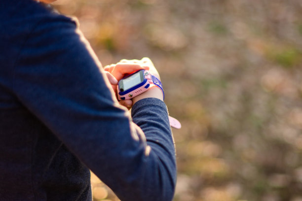 女孩在户外使用智能手表的特写图片下载